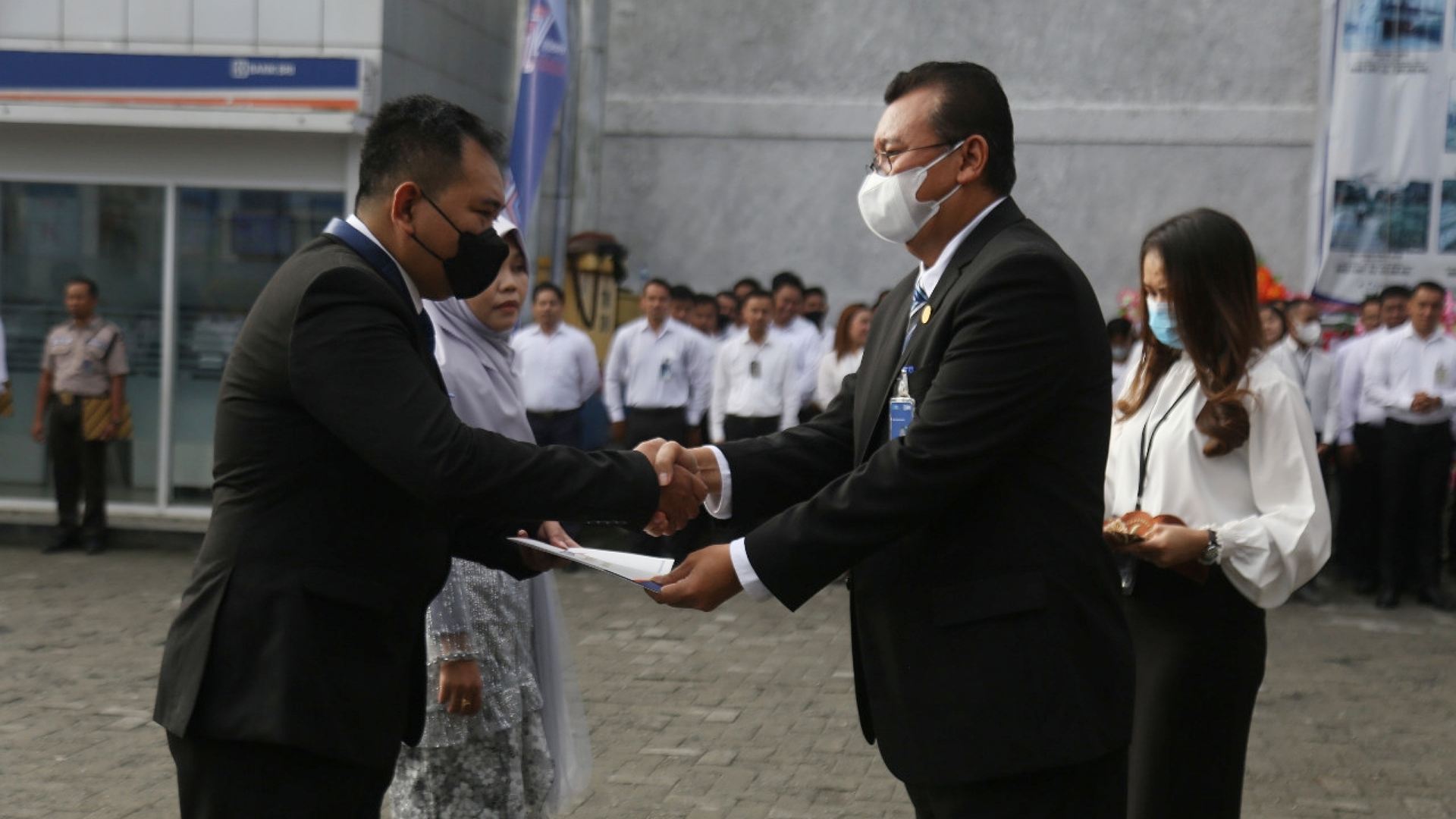 Pemimpin BRI Cabang Mimika, Budi Prasetyanto menyerahkan penghargaan yubilaris kepada dua pegawainya pada upacara peringatan HUT BRI ke-127 di Timika, Jumat (16/12/2022). Foto: Burhan/ Papua60detik