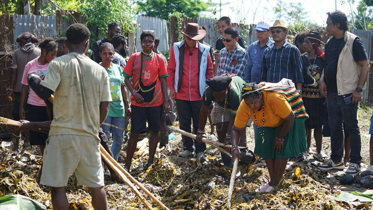 Tim AIYE bakar batu bersama warga Nduga di di Jalan Pepaya, Kelurahan Kamoro Jaya, Selasa (1/9/2024). Foto: Tim Media AIYE