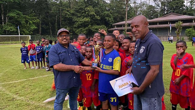 Senior Vice President Community Development PTFI, Nathan Kum serahkan piala ke pemenang Persemi Cup U-10 dan U-11 atau Grassroot Festival yang berlangsung di Kuala Kencana.  Foto: Faris/ Papua60detik