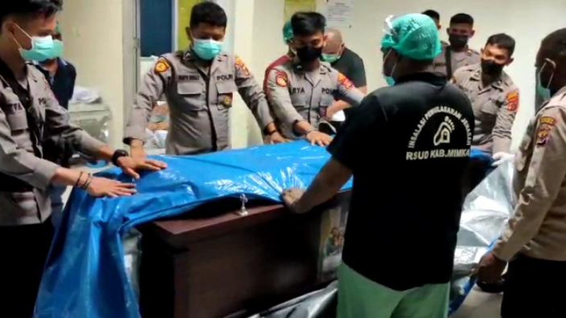 Personel Polres Mimika membantu membungkus peti jenazah salah satu korban penembakan KKB Nduga, Sabtu (16/7/2022). Foto: Salmawati Bakri/Papua60detik